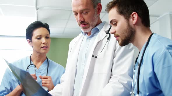 Three doctors studying a x-ray alt