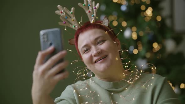 Middleaged Woman Wishes Her Relatives Christmas Via Video Call in Smartphone