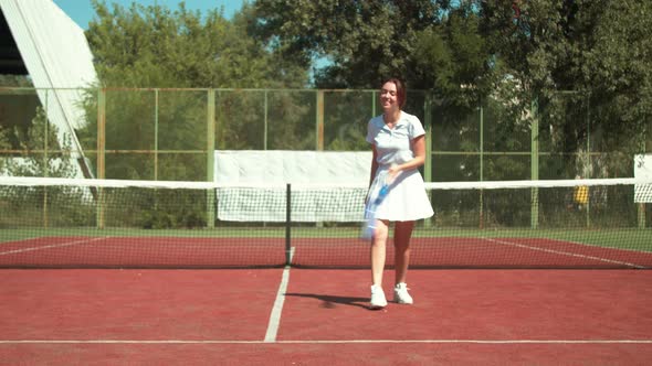 Happy Sportswoman Learning To Play Tennis on Court