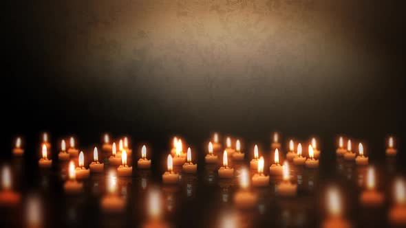 Candles lights on a wet grunge floor in a dark room. Dolly shot.
