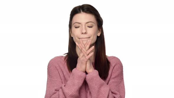 Portrait of Praying Mature Woman in Pink Sweater Putting Hands Together and Begging God for Luck alt