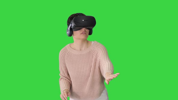 Cute Young Woman Walking and Using Interactive VR Headset on a Green Screen, Chroma Key alt