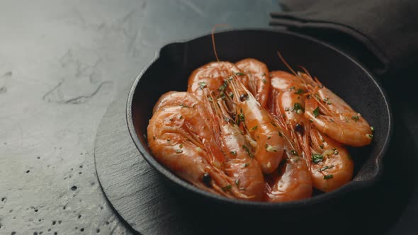 A small frying pan with shrimps in oil with spices