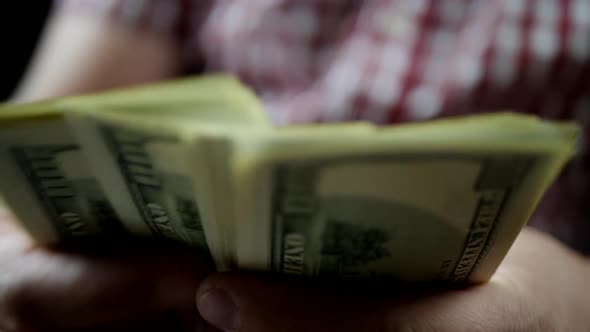 Hands Counting US Dollar Bills In Dark