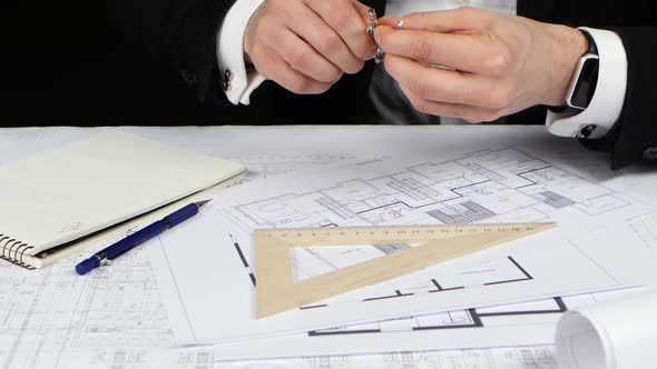 Businessman with a Compass and Ruler Makes Measurements for the Drawing. Close Up alt