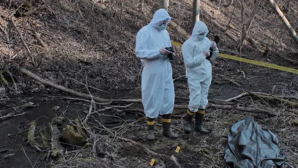 Forensic specialists working in the forest. Crime scene and police concept. alt