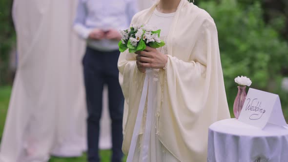 Unrecognizable Middle Eastern Woman Holding Wedding Bouquet in Hands Standing in Spring Summer alt