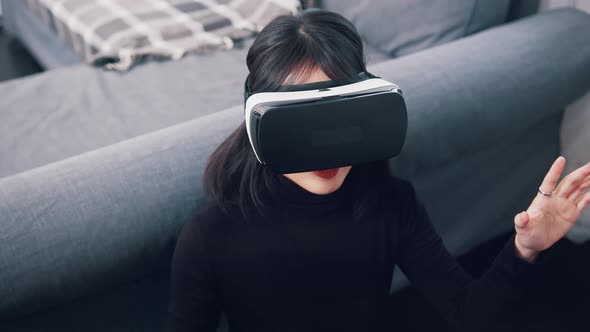 Young Asian Woman with VR Headset Experiencing Virtual Reality for the First Time alt
