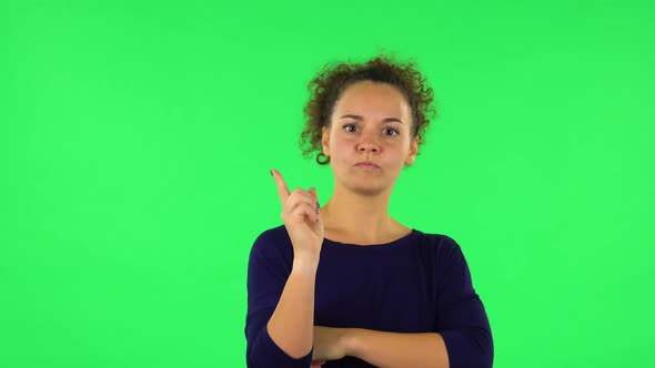 Portrait of Curly Woman Listening Carefully, Threatening with a Finger and Waves Her Head Negatively alt