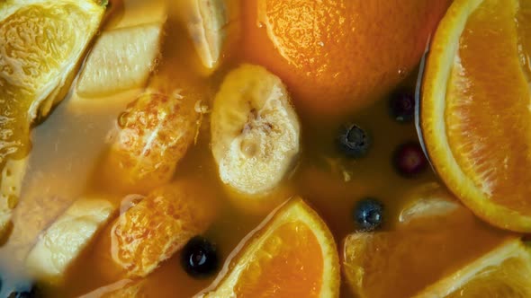 Making the Fresh Juice with Citrus Fruits Banana and Berries