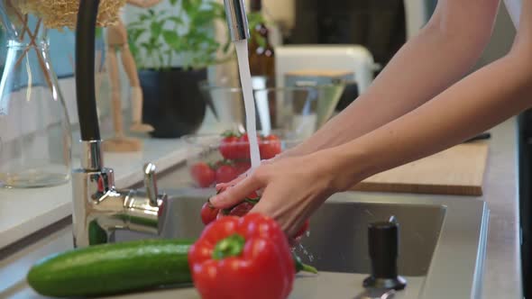 Woman Washing Tomato at Kitchen Sink alt