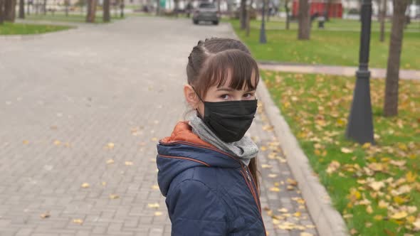 Teen hold leaves in autumn park.  alt