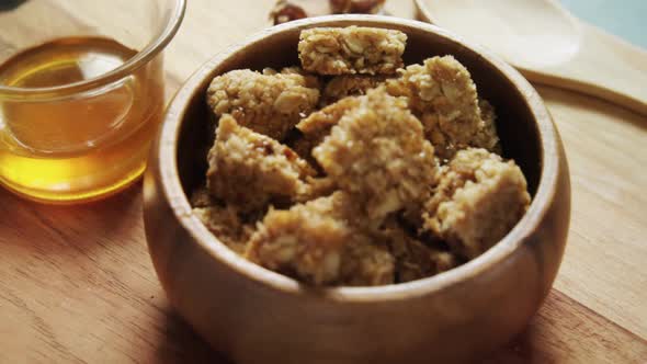 Granola bars in bowl with honey and fruits 4k alt