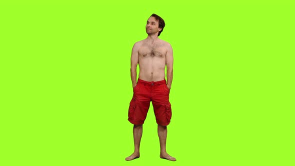 Topless Man in Red Shorts Standing Barefoot