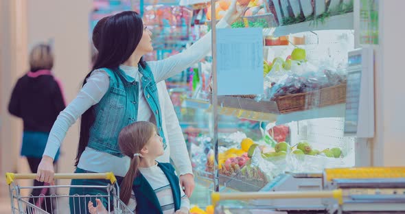 Mother Father and Children Picking Out Fruit in Supermarket alt