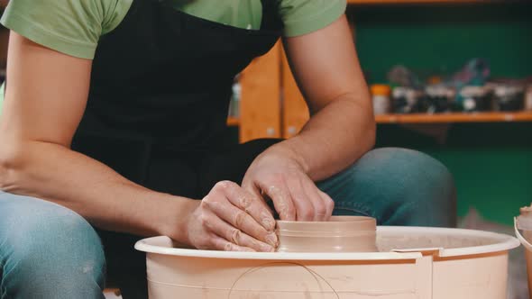 Pottery - the Master Is Raising the Walls of the Clay Bowl on the Potter's Wheel alt