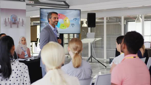 Male speaker addressing the audience at a business conference alt