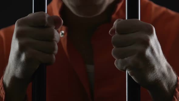 Depressed Prisoner Holding Cell Bars and Thinking About Committed Crime, Regret alt