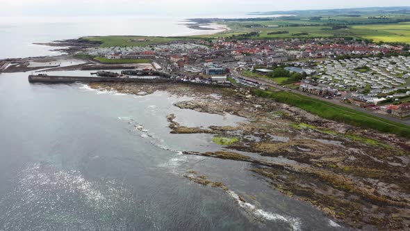 Aerial footage of the seaside coastal town of the village of Seahouses, a large village in the UK