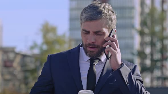 Businessman answering the phone on the street