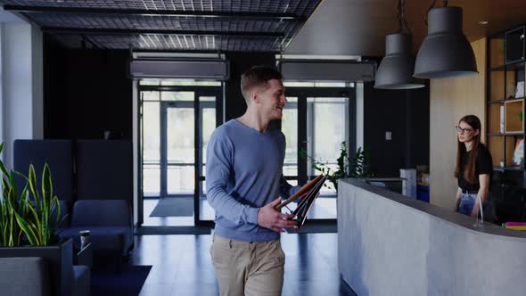 The Man Takes the Folder From the Secretary at the Office Reception alt