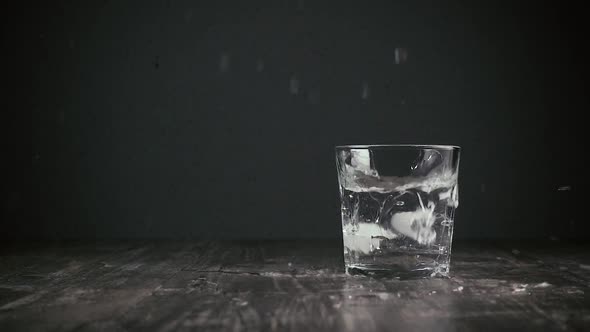 Ice Falls Into a Glass of Water