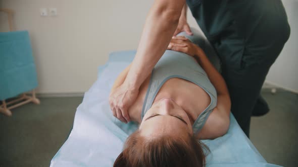 Woman Having an Osteopathic Treatment - Lying on the Couch While the Doctor Pushing on Her Body alt