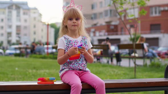 Child Girl Kid Playing Squeezing Antistress Silicone Toy Simple Dimple Pop It Game on Playground alt