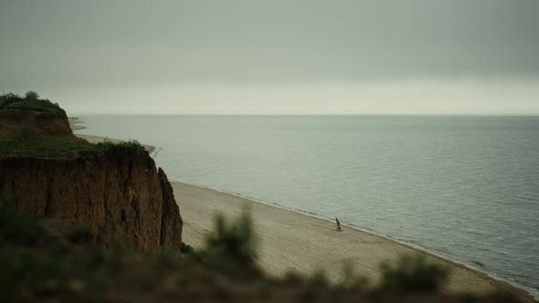 Scenic Green Hill Rising Over Sandy Beach Cloudy Day alt