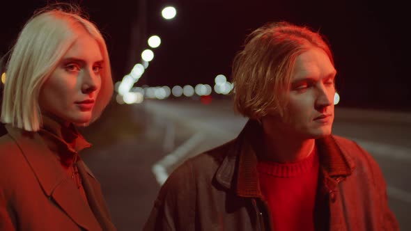 Couple Standing on Road at Night alt