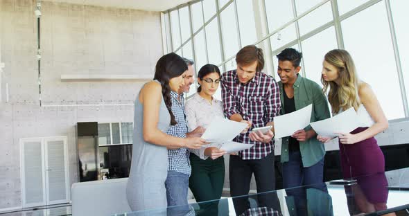Smiling executive discussing over document 4k alt