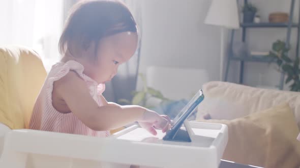 Asian Woman Working from Home while Sitting with Baby alt