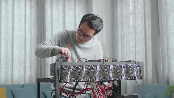 Asian Man Wearing Glasses Cleans The Mining Rig For Mining Cryptocurrency alt