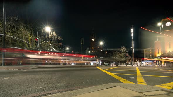 Traffic flying by Kings Cross Station at night. Time lapse of London City. alt