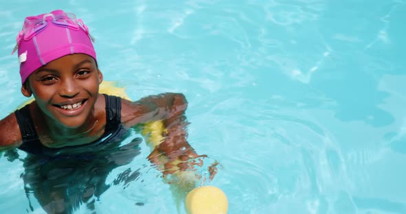 Portrait of young girl swimming with inflatable tube alt