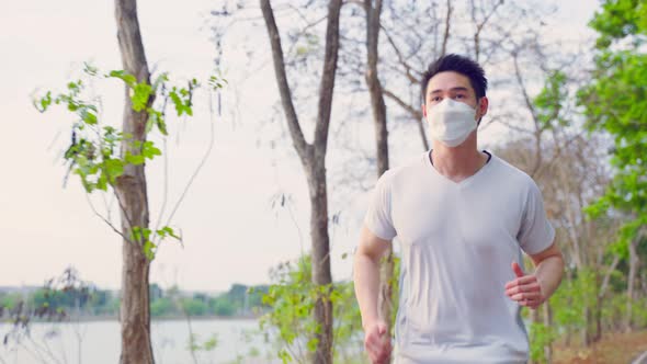 Asian young active sport male wear mask run on street in public park alt