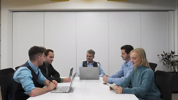 Relaxed business meeting in a startup office,five persons with laptops. alt