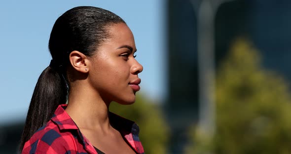 African American Woman covers mouth face hands, coughs outdoors. alt