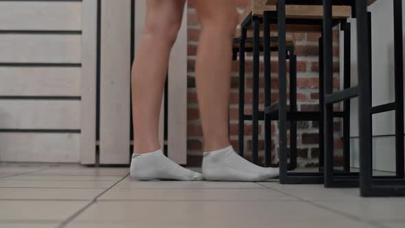Women's Feet in White Socks Walk Across the Tiles To the Kitchen