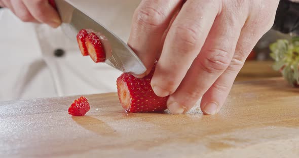Close up of a chef knife slicing a Strawberry alt