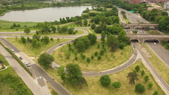 An aerial view over a parkway exit on a cloudy day. The drone orbits the circular exit in aclockwise alt