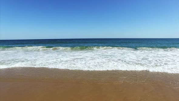 Sweeping drone shot of the water at the beach alt