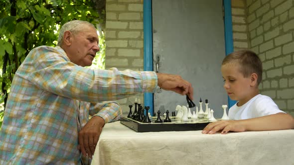 Boy 67 Years Old Plays Chess with His Grandfather