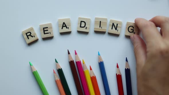 Word Reading Composing From Wooden Letters Tiles on White Background with Colorful Pencils alt