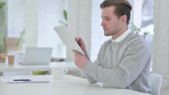 Hardworking Creative Young Man Using Tablet in Office alt