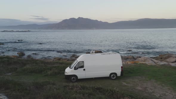 Camper van motorhome drone aerial view on a sea landscape living van life in Galiza, Spain alt