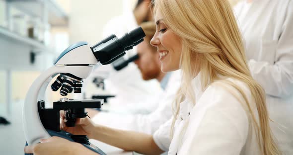 Young Scientist Looking Through Microscope in Laboratory