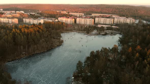 Ice Skating on Lake and Apartment Building Winter Scene Aerial