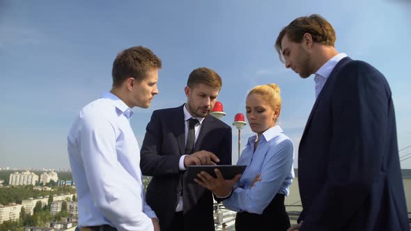 Business Team Discussing Project Details on Office Terrace Holding Tablet, Work