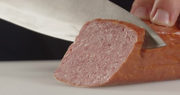 Slicing Meat. With A Sharp Knife Cuts Thin Slices Of Sausage.
